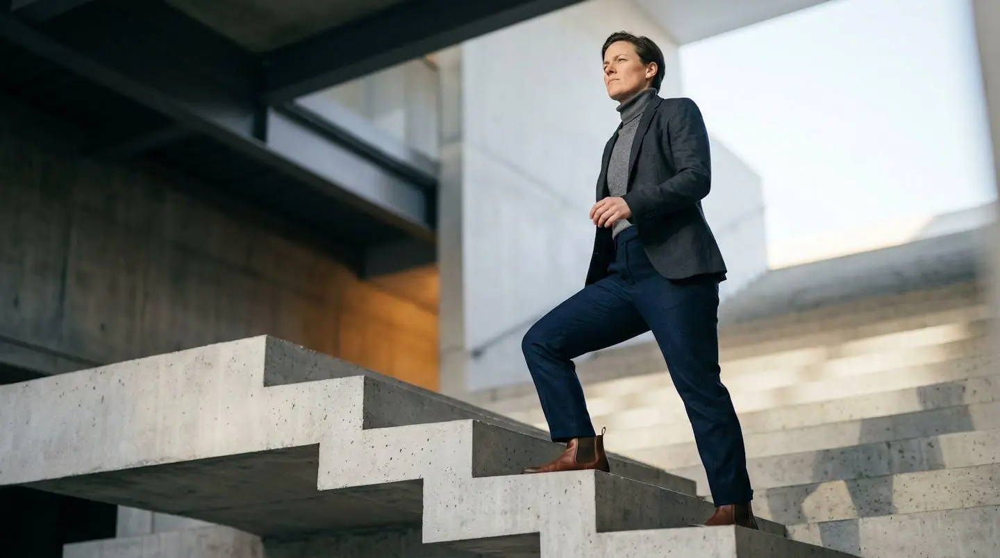 Professionnel confiant gravissant un escalier métaphorique vers une opportunité ambitieuse
